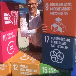 Myself surrounded by colorful cubes promoting the sustainable development goals.